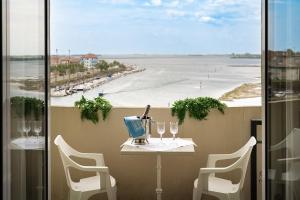 uma varanda com mesa e cadeiras e vista para o oceano em Hotel Eden em Grado