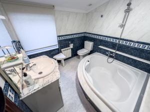 ein Badezimmer mit einer Badewanne, einem Waschbecken und einem WC in der Unterkunft Casa Gonzalo in Arou