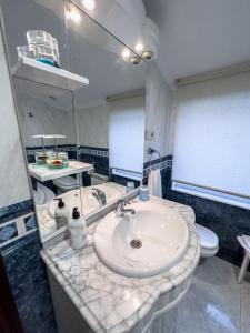 ein Badezimmer mit einem Waschbecken, einem WC und einem Spiegel in der Unterkunft Casa Gonzalo in Arou