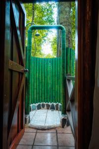 einen Eingang zu einem grünen Zaun mit einer Tür in der Unterkunft La Fortuna Natural Green in Fortuna