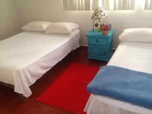 - une chambre avec 2 lits et une table bleue avec un tapis rouge dans l'établissement Casa para fines de semana, à Cuernavaca