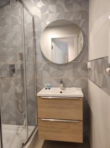 a bathroom with a sink and a shower and a mirror at Sileo Apart No.85 in Ustka