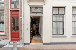 a red door on a white building with windows at Zocher6 BnB a monumental town house in the city center in Utrecht