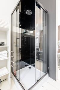 a glass shower in a bathroom with a black ceiling at Zocher6 BnB a monumental town house in the city center in Utrecht