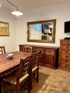 uma sala de jantar com uma mesa de madeira e um espelho em Raffinato Open Space em Orsogna