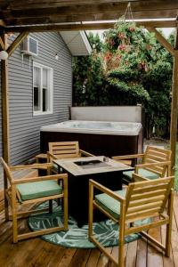 un patio con 3 sillas, una mesa y una bañera en Charming Kelowna Haven with Hot Tub, Parking, Pet-Friendly Bliss, en Kelowna