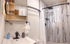 baño blanco con ducha y lavamanos en Eco Resort Condos en Aguada