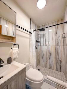 y baño con ducha, aseo y lavamanos. en Eco Resort Condos en Aguada