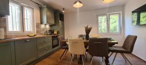 a kitchen with a table and chairs in a kitchen at Apartments Hvaranin in Stari Grad