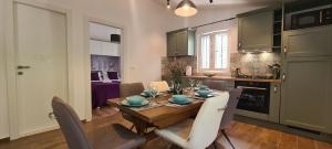 a kitchen with a wooden table and chairs in a kitchen at Apartments Hvaranin in Stari Grad