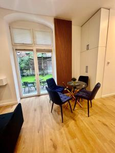 uma sala de estar com uma mesa e cadeiras e uma grande janela em Apartamenty Katowicka 58 - self check in 24h - by Kanclerz Investment em Chorzów