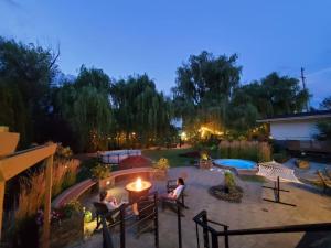 a group of people sitting in a garden at night at Serene Waterfront Escape with Pool, Hot Tub, Pet-Friendly Haven, & Breathtaking Views in Kelowna