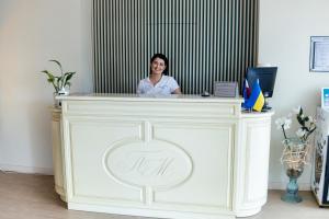 een vrouw achter een toonbank in een kamer bij Підгорецький маєток - готель in Pidhirtsi