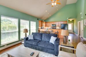 een woonkamer met een blauwe bank en een keuken bij Tranquil Home on Cedar Creek Fish, Kayak and Unwind in Tool