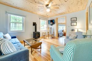 - un salon avec des canapés bleus et un plafond en bois dans l'établissement Enchanted Lake Huron Cottage with Beach Access!, à Rogers City