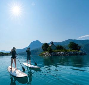 two people are on paddle boards in the water at Le Mélèze in Villar-Saint-Pancrace