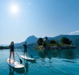 duas pessoas estão em pranchas de paddle na água em Le Mélèze em Villar-Saint-Pancrace