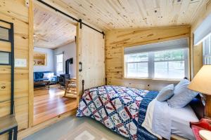 - une chambre avec un lit dans une pièce dotée de murs en bois dans l'établissement Enchanted Lake Huron Cottage with Beach Access!, à Rogers City