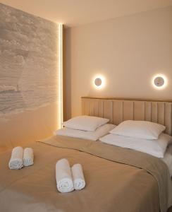 two beds in a room with white towels on them at Sileo Apart No.85 in Ustka