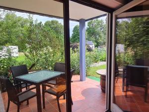 porche acristalado con mesa y sillas en el patio en Alpenblick Pang, en Rosenheim