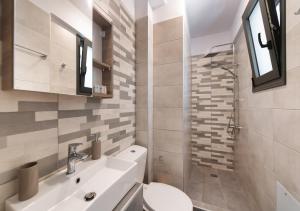 Un baño con lavabo, inodoro y ducha. en Blue Icons Lefkas, en Nikiana