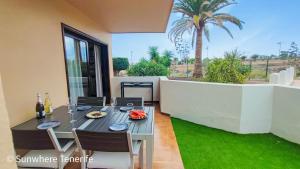Un comedor con mesa y sillas en un patio. en Spacious apartment with private garden in Tenerife south, en San Miguel de Abona