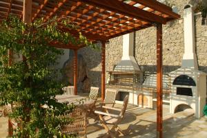 a patio with a wood fired oven in a house at Liberty - Classic luxury sea view villa with private pool, Panoramic views to Kommeno & Corfu old Town in Kommeno