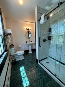 y baño con ducha, aseo y lavamanos. en Gifford House, en Provincetown