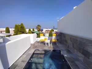 a swimming pool on the roof of a house at Chariot Apartments Santorini in Kamari
