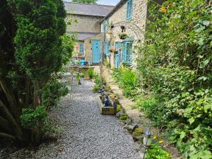 a garden in front of a house with plants at Rose Cottage - Cosy cottage in Millers Dale in Buxton