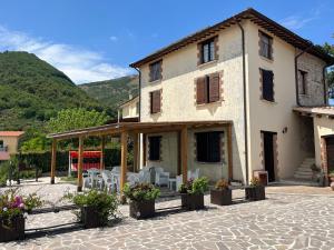 ein Haus mit einer Terrasse und Stühlen davor in der Unterkunft Casa Vacanze Vecchio Frantoio Residenza Leccino in Spoleto