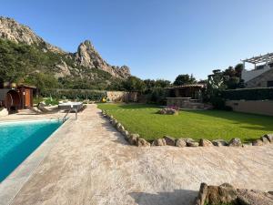 een achtertuin met een zwembad en een berg bij Antica Fonte Holiday Homes in San Pantaleo