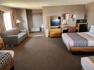 a hotel room with two beds and a flat screen tv at Satellite Inn in Alamogordo
