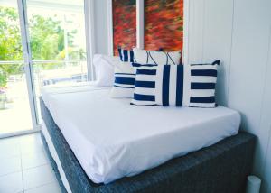 a bed in a room with blue and white pillows at CABAÑA EL ARBOL CARTAGENA in Cartagena de Indias