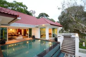 a swimming pool in front of a house at Independence Hotel Resort & Spa in Sihanoukville