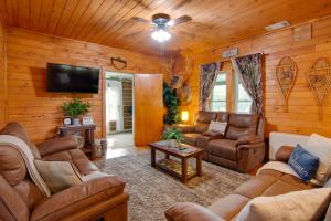 a living room with leather furniture and a flat screen tv at The Olde Homestead with Fire Pit and Mountain Views! in Coudersport