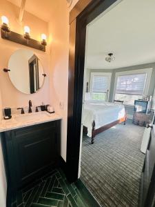 a bathroom with a bed and a sink and a mirror at Gifford House in Provincetown