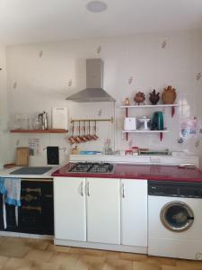 a kitchen with a stove and a washing machine at La antigua escuela bajo la Tesla in Incinillas