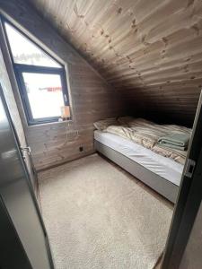 a small bedroom with a bed and a window at Rindabotn Fjelltun in Sogndal