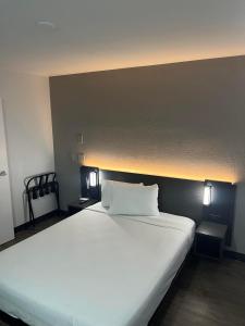 - une chambre avec un grand lit blanc et deux lumières dans l'établissement Motel 6-Lakeland, FL, à Lakeland