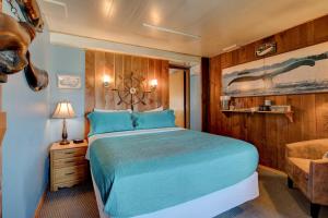 1 dormitorio con 1 cama azul y 1 silla en Moolack Shores Inn, en Newport