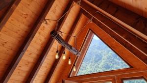 una lámpara de araña colgando del techo de una cabaña de madera en Bungaja Chalets en Shkodër