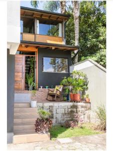 uma casa com uma varanda com plantas em vasos em Guest room Casa SEA em Florianópolis