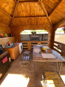 a large kitchen with a table in a wooden cabin at Коттеджи Эко-Дэм in Sukhum