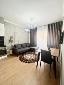 een woonkamer met een bank en een tafel bij Klidi Apartment in Tirana