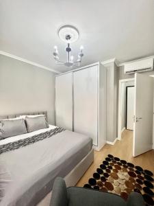 een slaapkamer met een groot bed en een stoel bij Klidi Apartment in Tirana