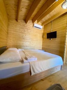 a bedroom with a bed in a wooden wall at Коттеджи Эко-Дэм in Sukhum