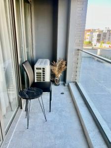 a small table and a chair on a balcony at Klidi Apartment in Tirana