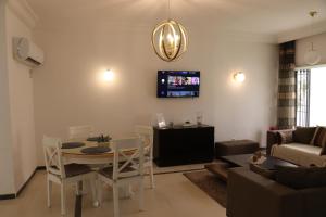 a living room with a table and chairs and a tv at Luxury house directly on the beach in Bizerte