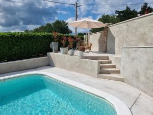 - Piscina con mesa y sombrilla en Casa Luana, en Roč